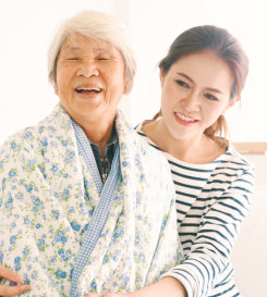 senior woman and caregiver smiling