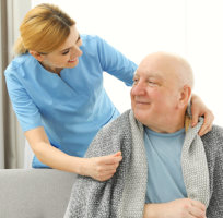 caregiver putting blanket at senior man