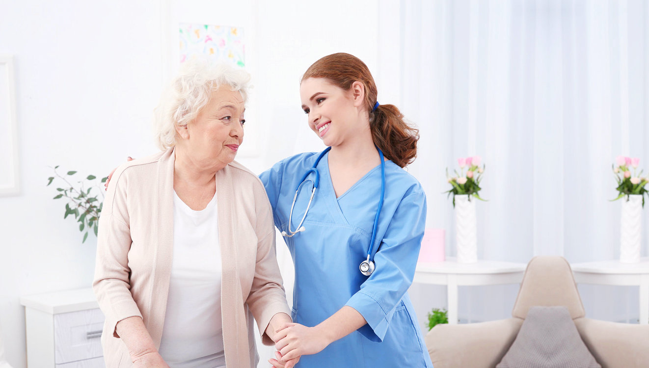 senior woman and nurse smiling