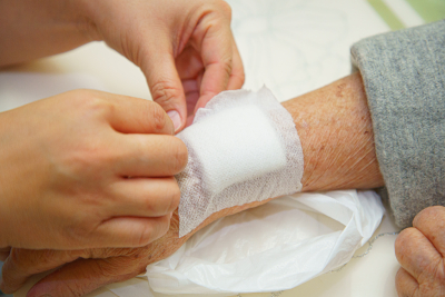 senior woman's arm getting bandaged