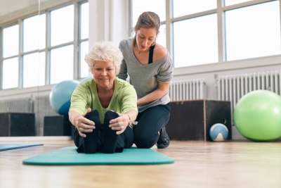 senior woman exercising with her trainer