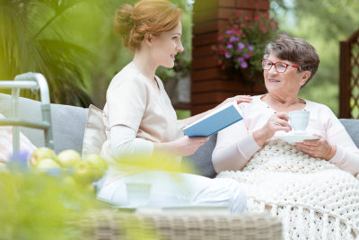 caregiver reading to her senior patient